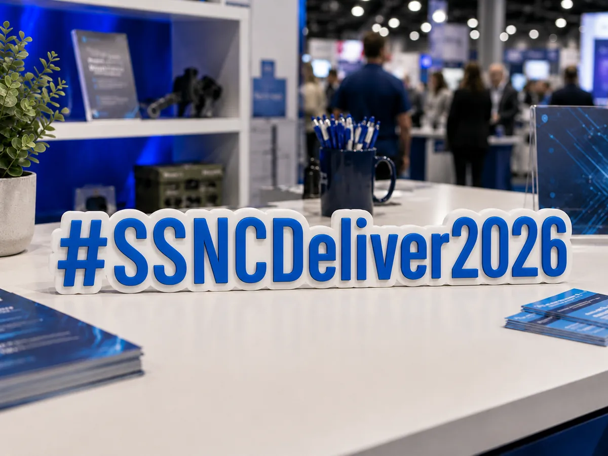 Blue and white 3D event hashtag sign displayed on a conference booth table