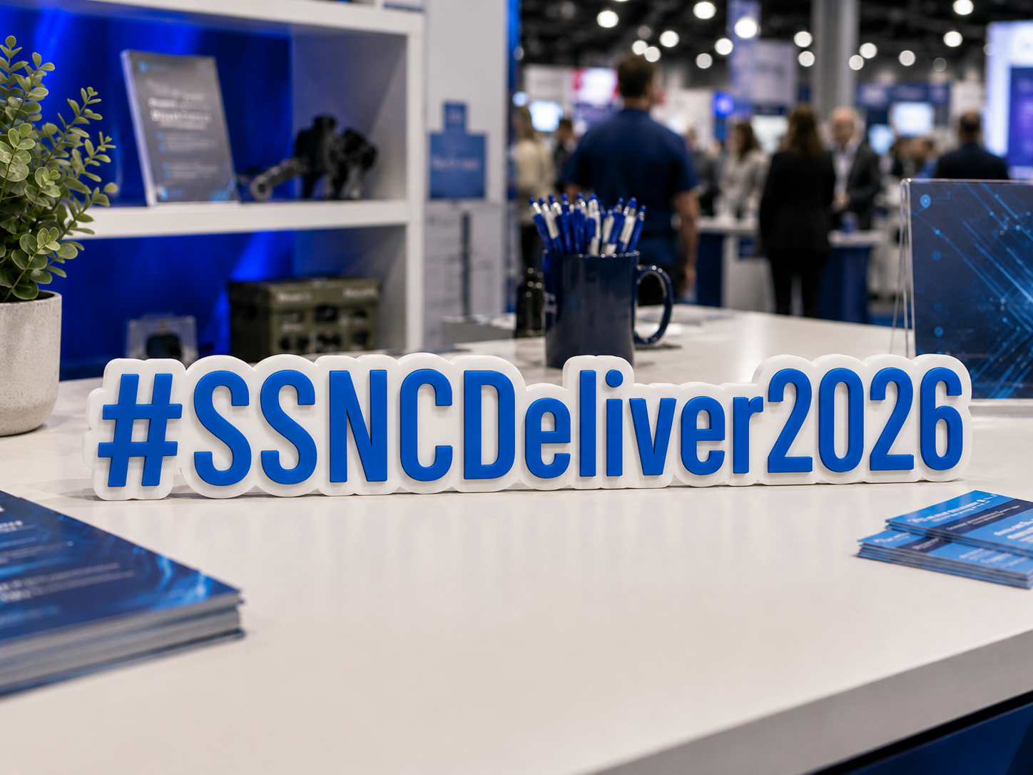 Blue and white 3D event hashtag sign displayed on a conference booth table